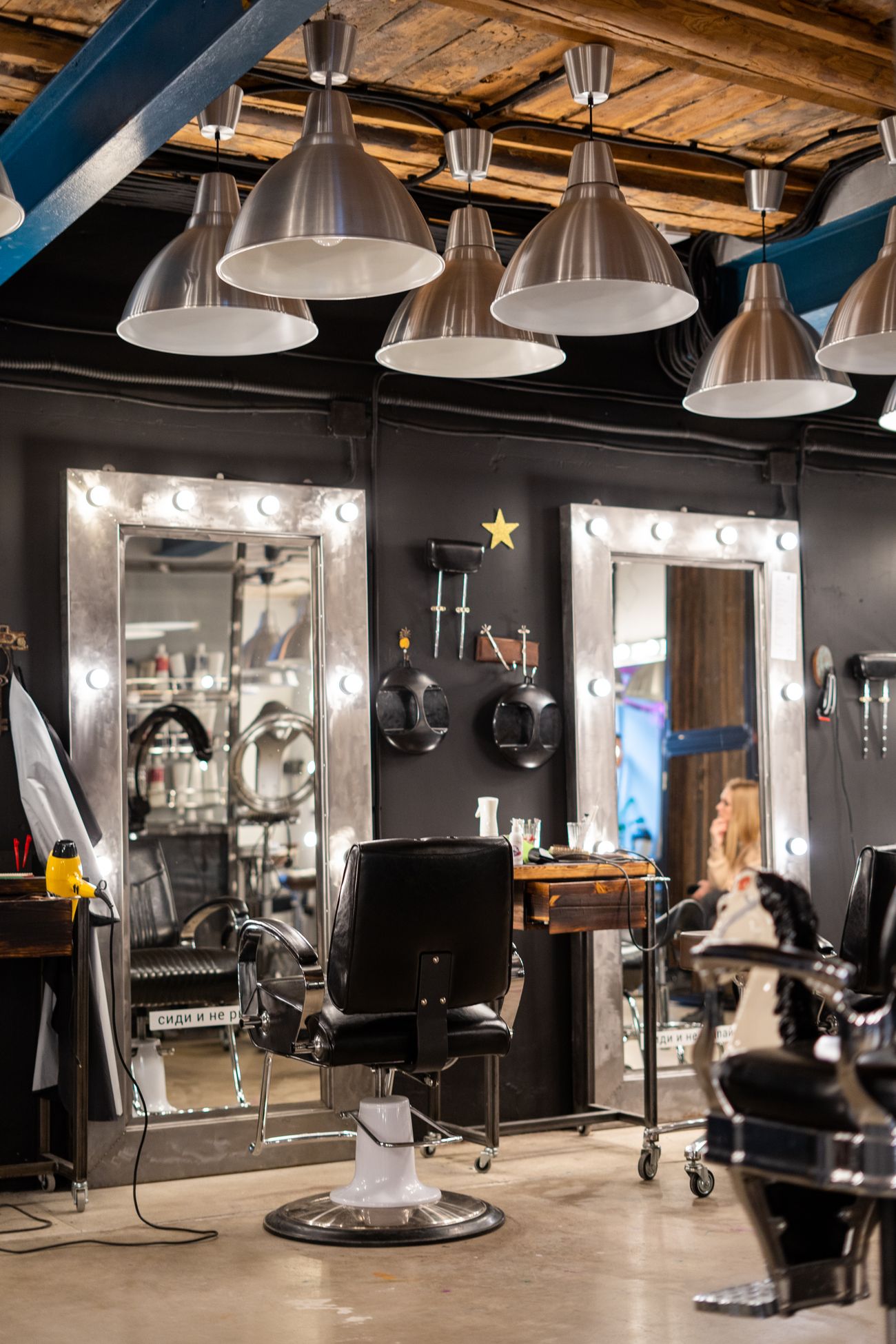 Puestos de barbería con espejos iluminados y lámparas de metal