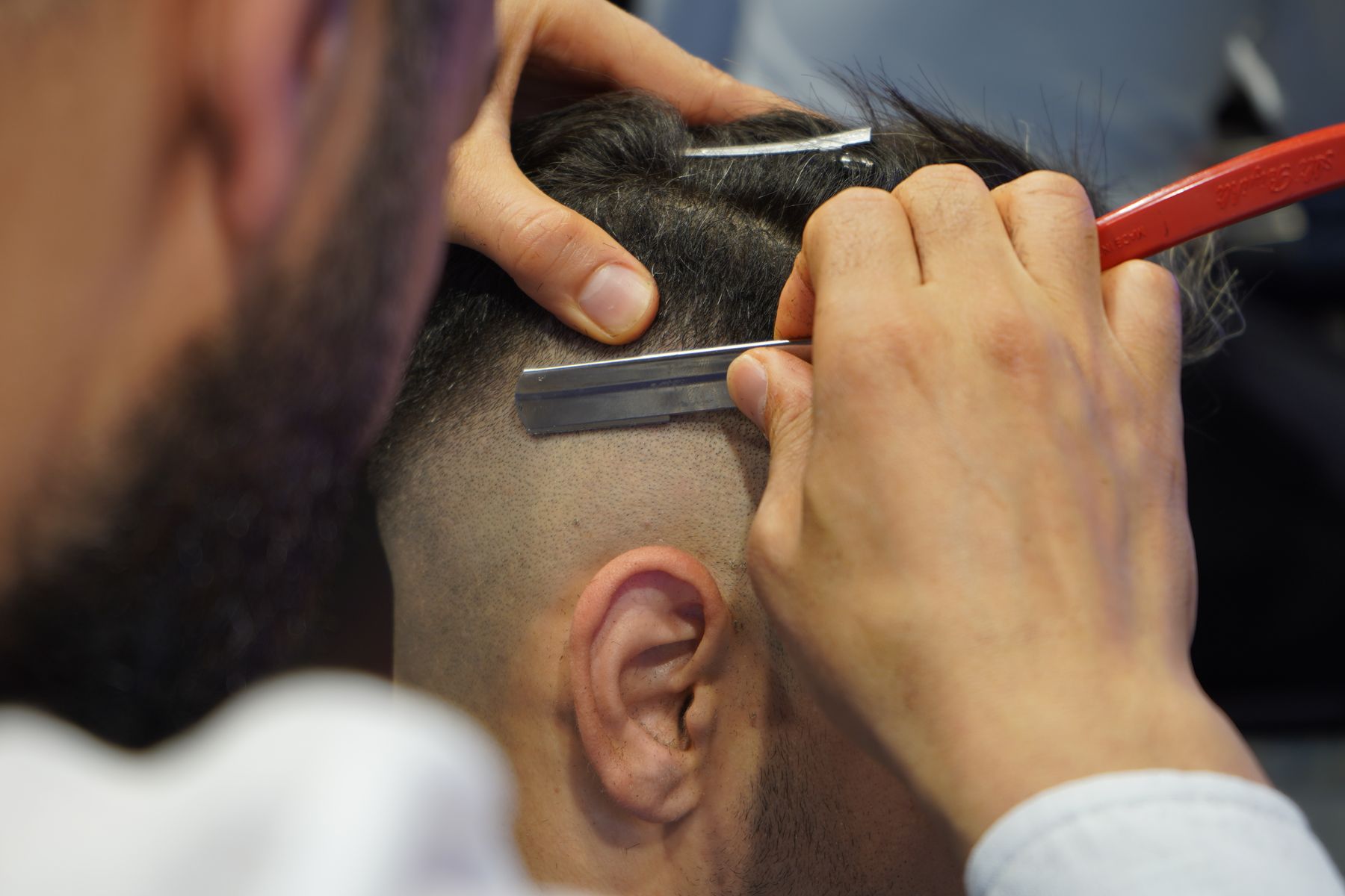 Barbero marcando un degradado con navaja